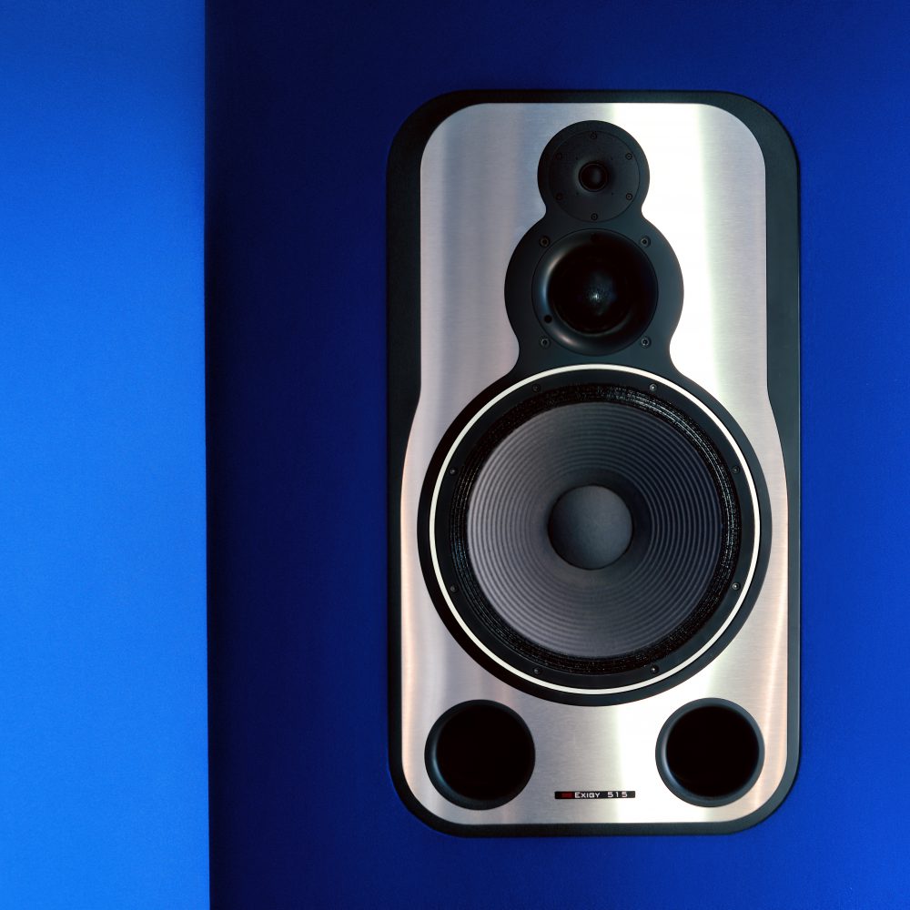 Close up product photo of a studio monitor speaker against a blue background