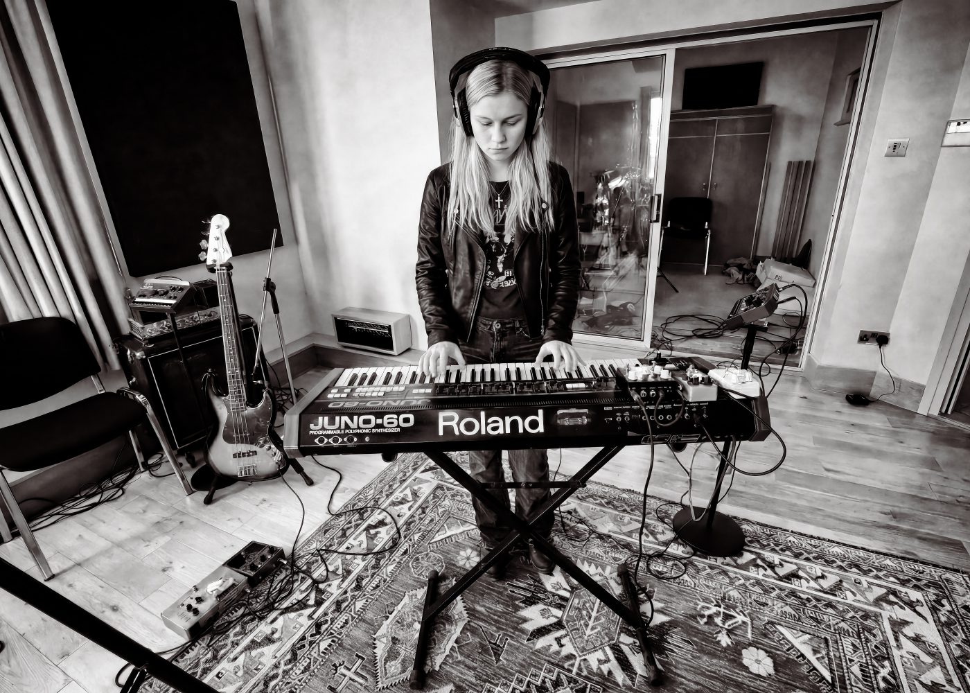 Black and white photo of a musician playing a Roland Juno-60 synthesizer