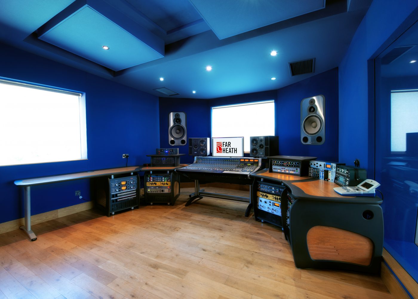 The blue control room showing the mixing desk and monitors
